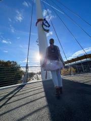 girl in a gray cardigan and jeans stands on a bridge, looking up at a colorful horse emblem on a pole, with a blue sky and a modern bridge with chio sign in the background
 : Stock Photo or Stock Video Download rcfotostock photos, images and assets rcfotostock | RC Photo Stock.: