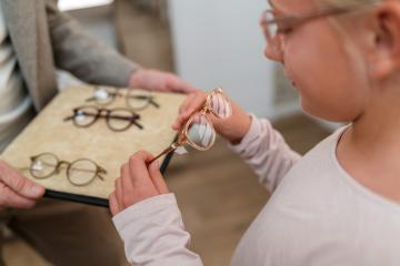 Girl trying on newglasses. She is looking at different frames on : Stock Photo or Stock Video Download rcfotostock photos, images and assets rcfotostock | RC Photo Stock.: