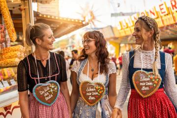 Girlfriends hafing fun at Bavarian fair or oktoberfest in Dirndl with Schenk mir dein Herz, Du bist die beste (German: Give me your heart, you are best ) written on gingerbreads heart : Stock Photo or Stock Video Download rcfotostock photos, images and assets rcfotostock | RC Photo Stock.:
