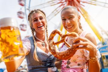 girlfriends toasting with pretzel or brezen and beer mug on a Bavarian fair or oktoberfest or duld in national costume or Dirndl- Stock Photo or Stock Video of rcfotostock | RC Photo Stock