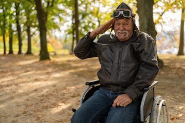 grandfather in a wheelchair, dressed in aviator gear, saluting playfully in a park with autumn trees in the background. Dementia retirement home concept image- Stock Photo or Stock Video of rcfotostock | RC Photo Stock