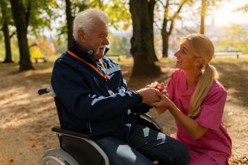 grandfather with a caregiver in a park, smiling and holding hands, man wearing an SOS button. Dementia retirement home concept image- Stock Photo or Stock Video of rcfotostock | RC Photo Stock
