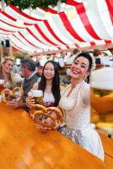 group of friends holding pretzels and large beer mugs, smiling and celebrating together at Oktoberfest or dult, with a lively atmosphere and the red and white striped tent in the background : Stock Photo or Stock Video Download rcfotostock photos, images and assets rcfotostock | RC Photo Stock.: