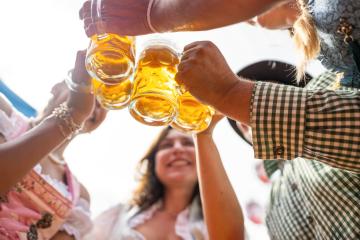 Group of friends joyfully toasting with beer mugs under a bright sky at Oktoberfest or Dult in germany- Stock Photo or Stock Video of rcfotostock | RC Photo Stock