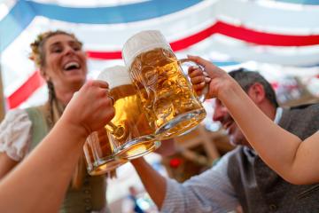 Group of Happy friends celebrating at Oktoberfest, raising beer mugs for a toast in a festive atmosphere under colorful tent with foam-filled beer mugs and laughter : Stock Photo or Stock Video Download rcfotostock photos, images and assets rcfotostock | RC Photo Stock.: