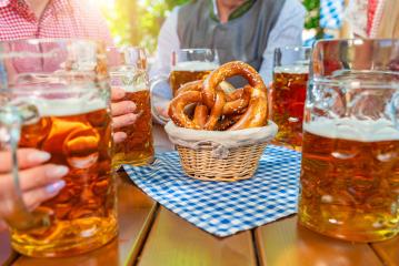 Group of happy friends drinking beer stein with brezen at Oktoberfest in bavaria- Stock Photo or Stock Video of rcfotostock | RC Photo Stock