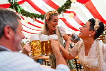 Group of people enjoying a fun moment, raising beer mugs together at a oktoberfest or dult festival, with joyful smiles and a festive atmosphere : Stock Photo or Stock Video Download rcfotostock photos, images and assets rcfotostock | RC Photo Stock.: