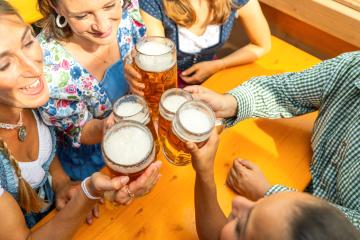 Group of people in traditional Bavarian outfits or tracht toasting with beer steins in a beer tent at  oktoberfest festival or dult in germany- Stock Photo or Stock Video of rcfotostock | RC Photo Stock