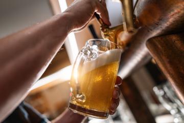 Hand holding a beer glass being filled from a tap, with a focus on the beer and foam- Stock Photo or Stock Video of rcfotostock | RC Photo Stock