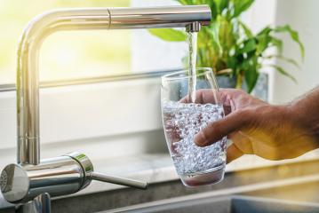 Hand holding a glass of water poured from the kitchen faucet- Stock Photo or Stock Video of rcfotostock | RC Photo Stock