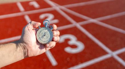 Hand holding a stopwatch on a red running track, numbers on lanes visible, sunny day- Stock Photo or Stock Video of rcfotostock | RC Photo Stock