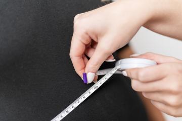 Hands using a measuring tape on a black female torso for a health analysis. Fitness and health concept image : Stock Photo or Stock Video Download rcfotostock photos, images and assets rcfotostock | RC Photo Stock.: