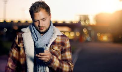 Handsome young man sms texting using app on smart phone at autum /summer sunset in city- Stock Photo or Stock Video of rcfotostock | RC Photo Stock