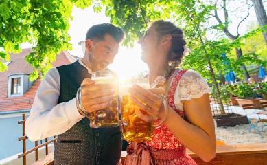 Happy Couple in Bavarian Beer garden or oktoberfest and enjoy the beer and the sun- Stock Photo or Stock Video of rcfotostock | RC Photo Stock
