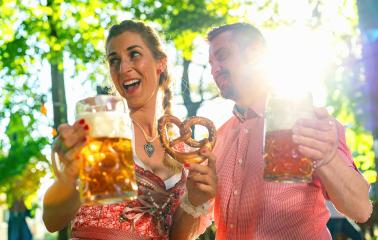 Happy Couple in Beer garden or oktoberfest making party and enjoying a glass of beer and the sun- Stock Photo or Stock Video of rcfotostock | RC Photo Stock