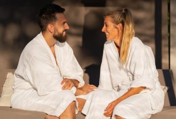 Happy couple in white robes talking and smiling in the sunlight- Stock Photo or Stock Video of rcfotostock | RC Photo Stock