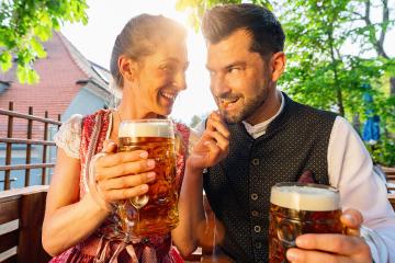 Happy Couple sitting in Beer garden and feeding with Pretzel Sticks enjoy the beer and the sun- Stock Photo or Stock Video of rcfotostock | RC Photo Stock