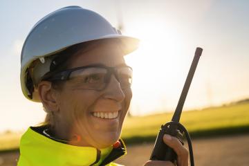 happy female engineer talking in a walkie talkie to checking wind turbine system at a windfarm on sunset : Stock Photo or Stock Video Download rcfotostock photos, images and assets rcfotostock | RC Photo Stock.: