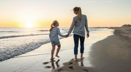 Happy mother and daughter walking together on the beach in holiday. Family holding hands enjoying the sunset on the beach. Happy family travel and vacations concept image. - Stock Photo or Stock Video of rcfotostock | RC Photo Stock
