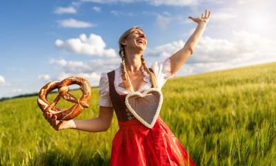 Happy party woman in Bavarian dirndl with a gingerbread heart, holding a pretzel in a wheat field celebrating Oktoberfest or dult festival in munich, with copyspace for your individual text. : Stock Photo or Stock Video Download rcfotostock photos, images and assets rcfotostock | RC Photo Stock.: