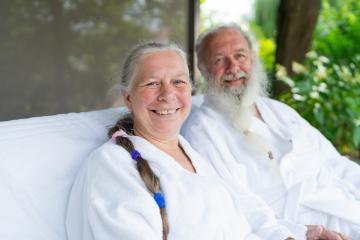 Happy similing senior couple relaxing together on bed lounge at wellness spa resort in the garden. Senior Moments concept image- Stock Photo or Stock Video of rcfotostock | RC Photo Stock