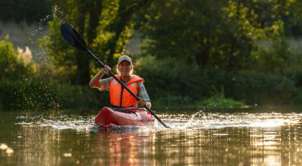 Happy woman kayaking on a sunny day, splashing water with her paddle, wearing an orange life jacket at summer.Kayak Water Sports concept image- Stock Photo or Stock Video of rcfotostock | RC Photo Stock