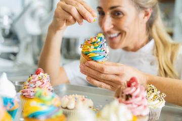 happy women in pastry bakery as confectioner sprinkles candies topping on a colorful muffin by hand : Stock Photo or Stock Video Download rcfotostock photos, images and assets rcfotostock | RC Photo Stock.: