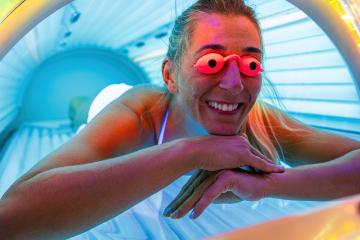 happy young woman tanning in solarium with glasses- Stock Photo or Stock Video of rcfotostock | RC Photo Stock