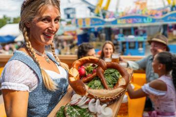 In oktoberfest in Bavaria, Germany - beer and snacks are served by a smiling waitress in traditional Bavarian dress or dirndl- Stock Photo or Stock Video of rcfotostock | RC Photo Stock