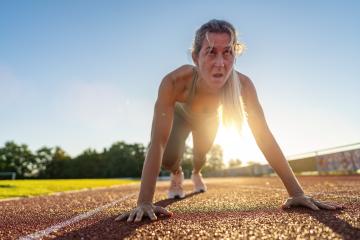 Intense female athlete at starting line on race track during sunset- Stock Photo or Stock Video of rcfotostock | RC Photo Stock
