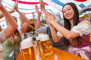 International friends at Oktoberfest or dult cheerfully clapping and smiling at a beer table with large beer mugs under a festive red and blue tent in a lively Bavarian atmosphere in munich : Stock Photo or Stock Video Download rcfotostock photos, images and assets rcfotostock | RC Photo Stock.: