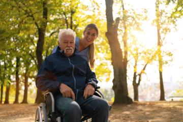 Joyful elderly man in a wheelchair going for a walk with a nurse, both smiling in a sunlit park with autumn trees- Stock Photo or Stock Video of rcfotostock | RC Photo Stock
