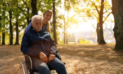 Joyful grandfather in a wheelchair and his nurse going for a walk in a sunlit park at nursery home, both sharing a smile- Stock Photo or Stock Video of rcfotostock | RC Photo Stock