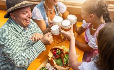 joyful group of friends clinking beer mugs at a table with a large pretzel, in a beer tent and celebrating at a Oktoberfest or dult : Stock Photo or Stock Video Download rcfotostock photos, images and assets rcfotostock | RC Photo Stock.: