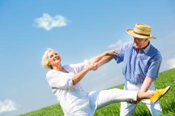 Joyful senior couple dancing in a sunny meadow, holding hands, with blue skies and green grass around them, expressing happiness, freedom, and an active lifestyle in a bright outdoor setting : Stock Photo or Stock Video Download rcfotostock photos, images and assets rcfotostock | RC Photo Stock.: