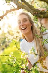 Laughing mature woman enjoying a sunny day in a blooming apple tree during spring : Stock Photo or Stock Video Download rcfotostock photos, images and assets rcfotostock | RC Photo Stock.: