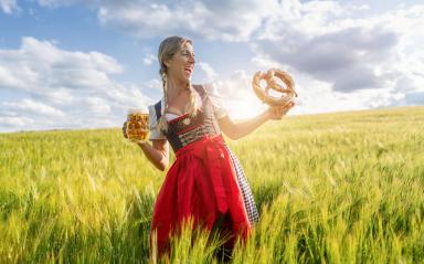 Laughing woman in traditional German tracht with beer and pretzel in a wheat field ready for Oktoberfest in munich. : Stock Photo or Stock Video Download rcfotostock photos, images and assets rcfotostock | RC Photo Stock.: