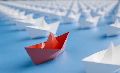 Leadership concept with red paper ship leading among white paper boats- Stock Photo or Stock Video of rcfotostock | RC Photo Stock