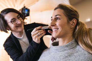 make up assistant applying make up with beauty brush to the face of a happy model for a photoshoot oder movie on location.- Stock Photo or Stock Video of rcfotostock | RC Photo Stock