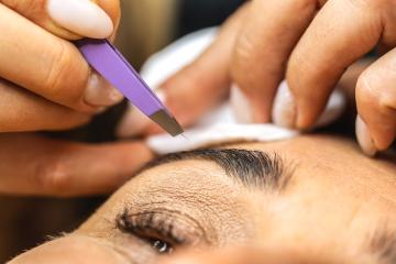 Make-up artist plucks eyebrows with tweezers to a woman. Beautiful thick eyebrows close up. Makeup and Cosmetology concept image : Stock Photo or Stock Video Download rcfotostock photos, images and assets rcfotostock | RC Photo Stock.: