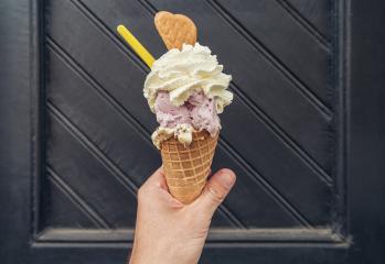 Male hand holding ice cream with cream and cookie against black doorstep. POV image : Stock Photo or Stock Video Download rcfotostock photos, images and assets rcfotostock | RC Photo Stock.: