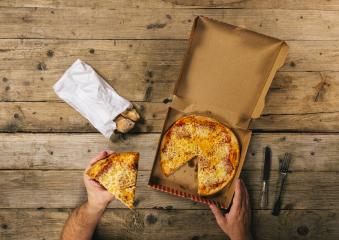 male hands holding pizza piece with delivery box ready to eat over a wooden table. Top view- Stock Photo or Stock Video of rcfotostock | RC Photo Stock