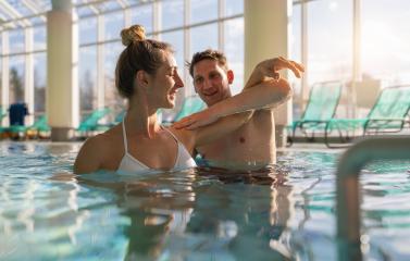Male trainer assisting with shoulder exercise in spa resort pool- Stock Photo or Stock Video of rcfotostock | RC Photo Stock