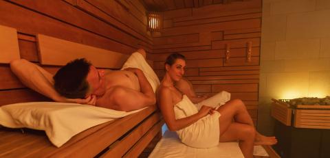 man and a woman relaxing in a finnish sauna with warm lighting and wooden walls. Wellness Spa Hotel Conept image. : Stock Photo or Stock Video Download rcfotostock photos, images and assets rcfotostock | RC Photo Stock.: