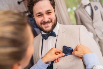 Man being fitted for a suit, tailor adjusts a blue pocket square, both smiling in a wedding store : Stock Photo or Stock Video Download rcfotostock photos, images and assets rcfotostock | RC Photo Stock.: