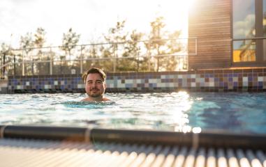 Man enjoying a relaxed swim in a pool at a hotel on sunset, sunl- Stock Photo or Stock Video of rcfotostock | RC Photo Stock