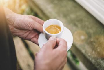 Man holding afresh tasty espresso cup of hot coffee in a cafe- Stock Photo or Stock Video of rcfotostock | RC-Photo-Stock