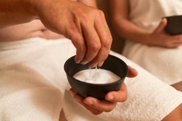 Man holds a bowl of salt in his hand at the steam bath or hammam to exfoliate the skin for body massage in a spa or wellness resort - Stock Photo or Stock Video of rcfotostock | RC Photo Stock