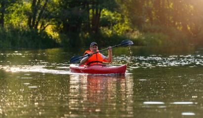Man in orange life jacket kayaking in red kayak on a river, golden sunlight reflecting on water. Kayak Water Sports concept image- Stock Photo or Stock Video of rcfotostock | RC Photo Stock
