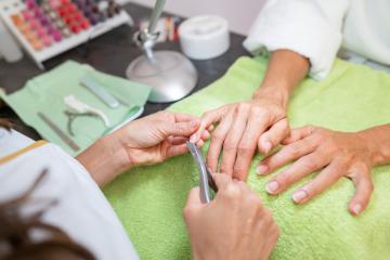 Manicurist trimming cuticles of a client at a salon with tools on table in a beauty salon- Stock Photo or Stock Video of rcfotostock | RC Photo Stock